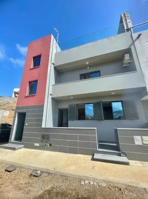 a tall building with a red and white at Modern Apartment in Praia Baixo - 1 min Walking to Beach in Praia Baixo