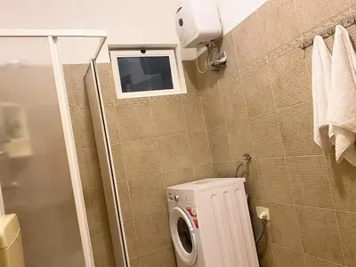 a bathroom with a washing machine and a window at Studio Apt Bounty Condominium, Santa Maria in Santa Maria