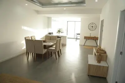 a dining room and living room with a table and chairs at Maison da Praia in Praia
