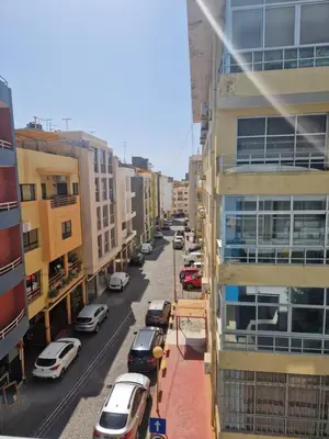 a city street with cars parked next to buildings at Condomínio palma azul II in Praia