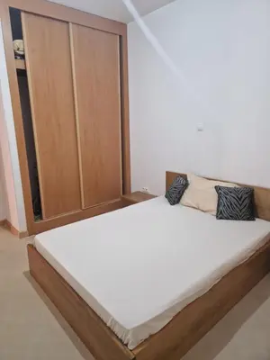 a large bed in a room with a wooden cabinet at Condomínio palma azul II in Praia