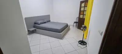 a small bedroom with a bed and a tiled floor at Casa Cor de Rosa in Praia