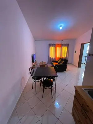 a living room with a table and chairs and a couch at Casa Cor de Rosa in Praia