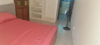 a room with a bed with a red blanket and a tripod at Casa Cor de Rosa in Praia