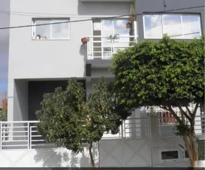 a white building with a tree in front of it at Residencia BB in Praia