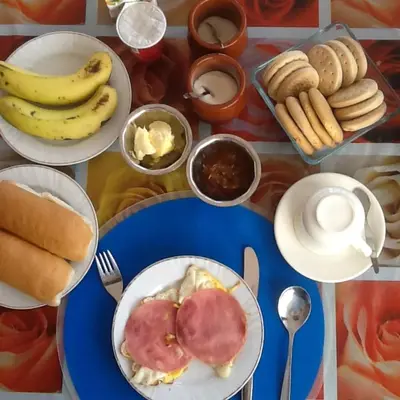 a table topped with plates of food with bananas and other foods at Questel BronQ in Chã da Igreja