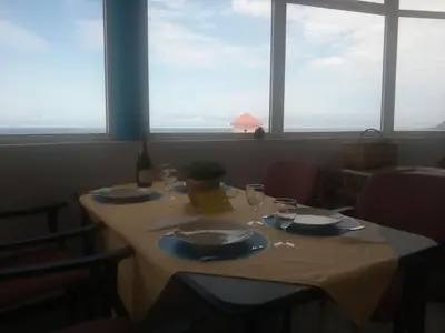a table with plates and wine glasses in a room with windows at Questel BronQ in Chã da Igreja