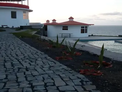 a stone pathway leading to a house and the ocean at Questel BronQ in Chã da Igreja