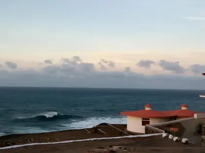 a house on a cliff near the ocean at Questel BronQ in Chã da Igreja