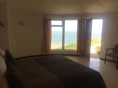 a bedroom with a bed and a view of the ocean at Questel BronQ in Chã da Igreja