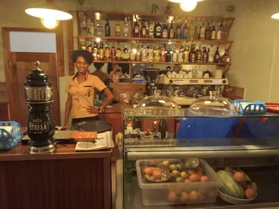 a woman is standing behind a counter in a bar at Pandora Ocean View am Praia Cabral in Sal Rei