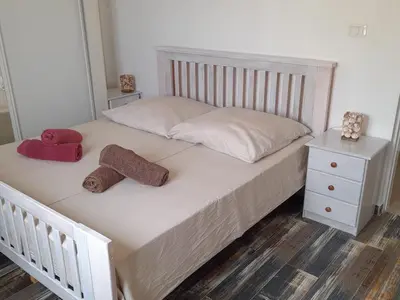 a white bed with two towels and a night stand at Pandora Ocean View am Praia Cabral in Sal Rei