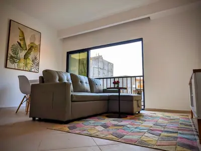 a living room with a couch and a large window at Tarrafal Bay - 1Bdr Apt - Sea view -1 in Tarrafal