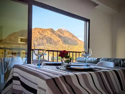 a table with a view of a mountain through a window at Tarrafal Bay - 1Bdr Apt - Sea view -1 in Tarrafal