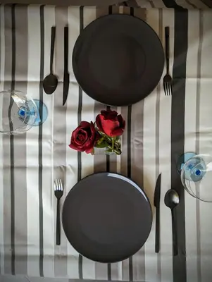 a table with black plates and a red rose on it at Tarrafal Bay - 1Bdr Apt - Sea view -1 in Tarrafal