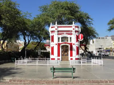 a bench in front of a red and white building at Casa Sofia in Mindelo