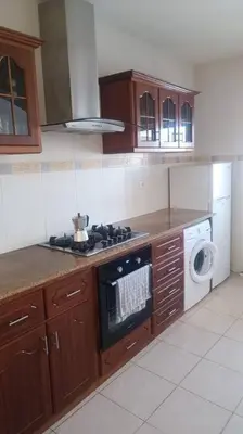 a kitchen with a stove and a washing machine at Casa Sofia in Mindelo