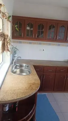 a kitchen with a sink and wooden cabinets at Casa Sofia in Mindelo