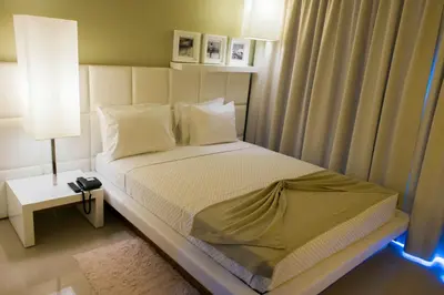 a bedroom with a bed and a night stand with a lamp at Hotel Vip Praia in Praia