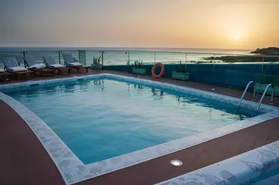 a swimming pool with a view of the ocean at Hotel Vip Praia in Praia