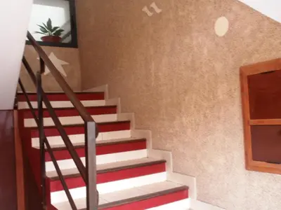 a stairwell with red and white stairs and a door at Zena Star in Tarrafal