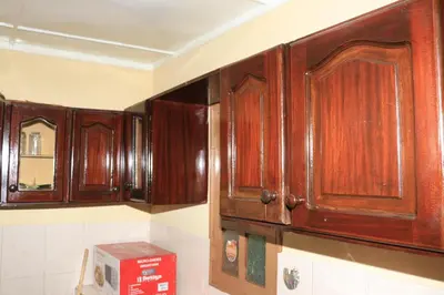 a kitchen with wooden cabinets on the wall at Ramos Apartamento in São Filipe