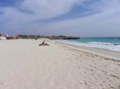 a group of people sitting on the beach at Penthouse with Panoramic Ocean Views and unlimited WiFi in Santa Maria