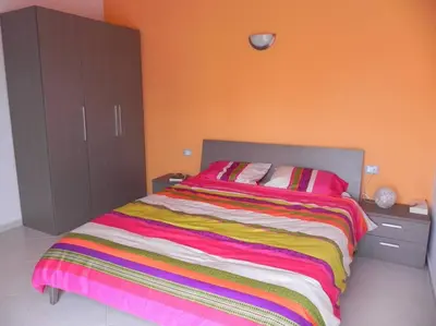 a bedroom with a bed with a colorful striped blanket at Penthouse with Panoramic Ocean Views and unlimited WiFi in Santa Maria