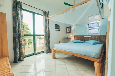 a bedroom with a bed and a large window at Casa Strela B&B Tarrafal in Tarrafal