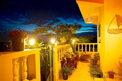 a balcony with a fence with plants and lights at Casa Strela B&B Tarrafal in Tarrafal