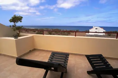 a balcony with two chairs and a view of the ocean at Casa Strela B&B Tarrafal in Tarrafal