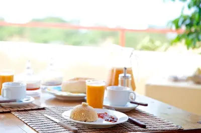 a table with a plate of food and orange juice at Casa Strela B&B Tarrafal in Tarrafal