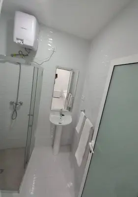 a white bathroom with a sink and a mirror at Apto T0 na Capital in Praia