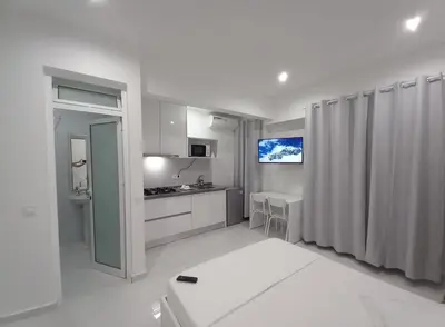 a white kitchen with a sink and a counter at Apto T0 na Capital in Praia