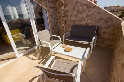 a balcony with chairs and a table and a chair at Calma de Sal Santana Ocean View Apartment in Santa Maria