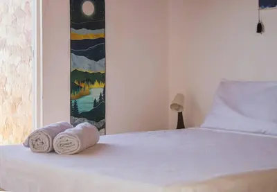a bedroom with a bed with two rolled towels on it at Calma de Sal Santana Ocean View Apartment in Santa Maria