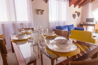 a dining room with a glass table with wine glasses at Calma de Sal Santana Ocean View Apartment in Santa Maria
