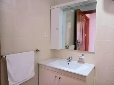 a bathroom with a white sink and a mirror at Apartamento em Santa Maria- Espaçoso&Confortável in Santa Maria