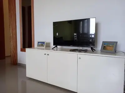 a flat screen tv on top of a white cabinet at Apartamento em Santa Maria- Espaçoso&Confortável in Santa Maria