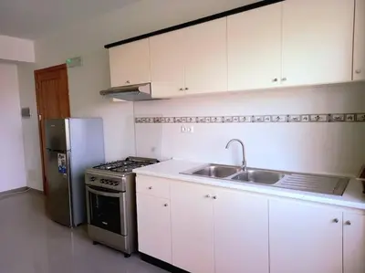 a kitchen with white cabinets and a stainless steel refrigerator at Apartamento em Santa Maria- Espaçoso&Confortável in Santa Maria