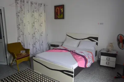 a bedroom with a bed and a chair in it at Casa Herminia in Tarrafal