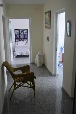 a room with a bed and a chair and a table at Casa Herminia in Tarrafal