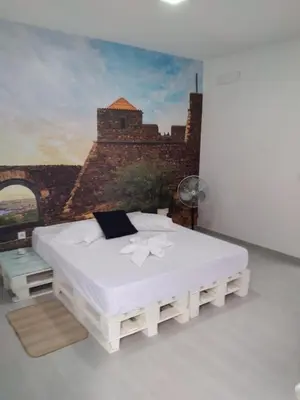 a bedroom with a bed with a painting on the wall at Palmira House in Cidade Velha