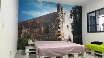 a bed in a room with a painting on the wall at Palmira House in Cidade Velha