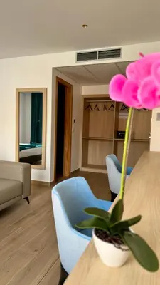 a living room with a table and a pink flower at Hôtel Blue Sky in Tarrafal