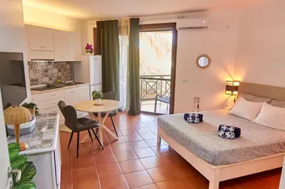 a bedroom with a bed and a kitchen with a table at Calma de Sal Porto Antigo II Beach apartment in Santa Maria