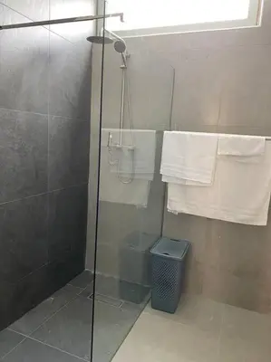 a shower with a glass door and a trash can at Apartamento sublime c/vista top. in Praia