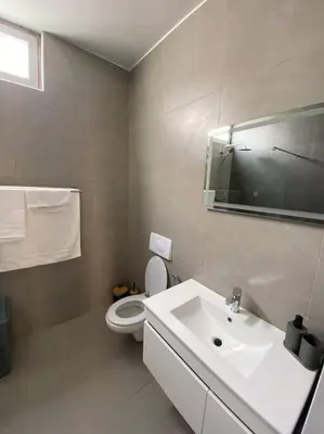 a white bathroom with a toilet and a sink at Apartamento sublime c/vista top. in Praia