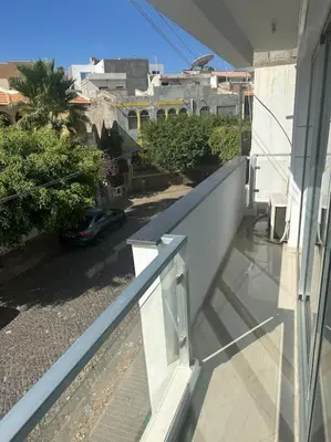 a balcony of a house with a car on the street at Appartement cosy et spacieux in Praia