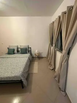 a bedroom with two beds and a window with curtains at Appartement cosy et spacieux in Praia